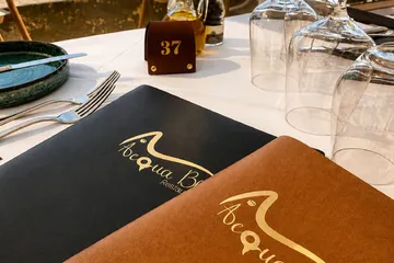 Two closed menus, one navy and one tan, on a set table